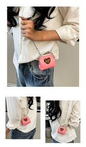 Close-up of pink heart-shaped mini purse with leopard print detail and silver chain