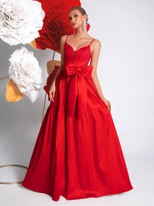 Detail of red evening dress with deep V-neck and oversized satin bow decoration