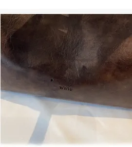 Close-up of brown leather texture featuring the Fashion trend WWTU embossed logo details