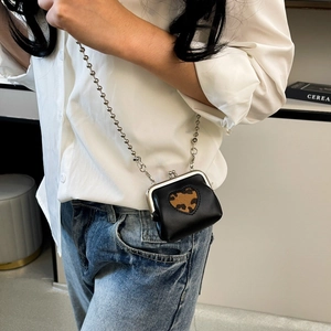 Mini black crossbody bag with leopard heart and silver chain shown on model outfit