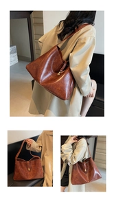 Detail view of a large brown tote bag with vintage texture and gold ball clasp
