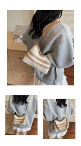 Detail view of woven bucket bag with brown leather trim and adjustable crossbody strap