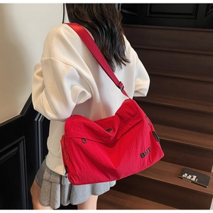 Détail du sac de sport en nylon rouge avec logo BNT brodé et bandoulière réglable