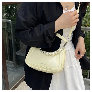 Detailed view of the creamy beige hobo bag with elegant pearl strap and logo detail