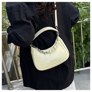 Detail of cream crescent crossbody bag with pearl chain handle and long strap