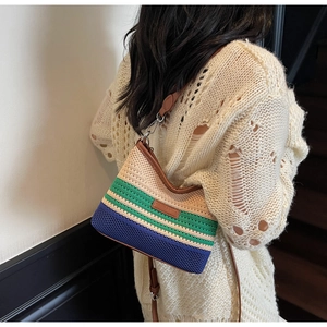 Detailed close-up of tricolor woven bucket bag with leather trim and shoulder strap