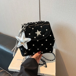 Detailansicht der glänzenden Stepptasche mit Strass-Stern und silbernem Kettenriemen