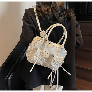 Dettaglio borsa in pelle bianco crema con fiocchi e foulard decorativo a pois neri
