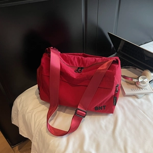 Détail du sac de sport en nylon rouge avec broderie BNT et bandoulière réglable