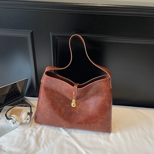 Detailed macro view of brown vintage texture leather tote bag with gold gourd buckle