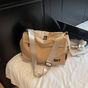 Détail du sac de voyage en nylon kaki avec logo BNT et bandoulière grise large