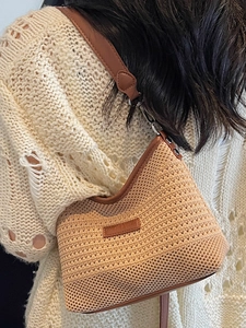 Chic beige woven bucket bag with brown leather trim and stylish shoulder strap detail