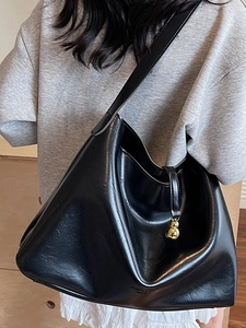 Minimalist black glossy leather hobo tote bag with a golden gourd charm detail
