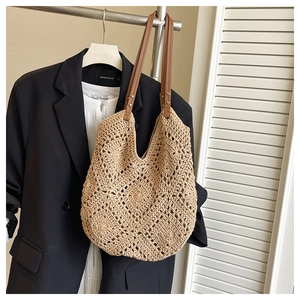 Close-up of beige crochet tote bag with hollow diamond pattern and brown faux leather straps