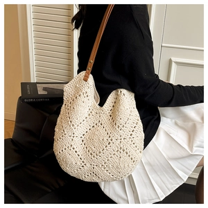 Detail of hand-woven beige tote bag with premium brown leather straps and metal rivets
