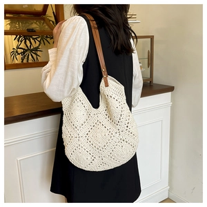Detail of hand-woven beige tote bag with leather strap and diamond crochet patterns