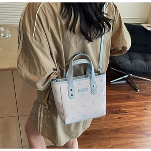 Litchi pattern leather bucket bag with blue deer print shown on model in home setting