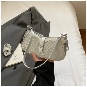 Detail of silver leopard print baguette bag featuring metal twist lock and shoulder strap