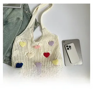 Flat lay of cream crochet flower tote bag next to a tablet showing its large capacity