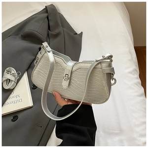 Detail view of silver baguette bag with embossed wavy texture and metallic buckle
