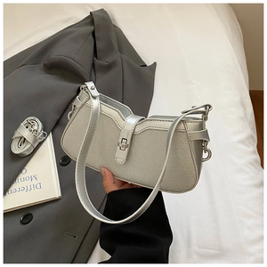 Detailed macro view of the silver textured weave and metallic clasp on the stylish baguette bag