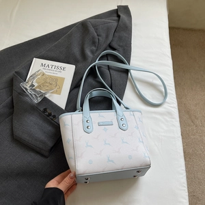 Detail view of the white pebble leather handbag with blue accents and deer print