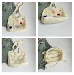 Detail view of cream knit tote bag showing colorful heart patches and hollow texture