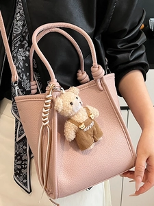 Sac à main en cuir grainé rose avec poignée nouée et charmant pendentif ours