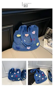 Close-up of dark blue crochet tote bag featuring multi-colored 3D heart-shaped knit patches