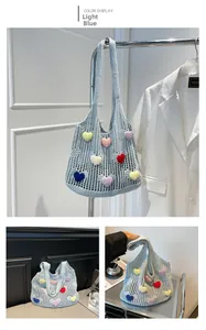 Detail of light blue crochet knit tote bag with 3D colorful heart patterns and long straps
