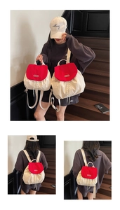 Detail of red and cream canvas backpack featuring drawstring closure and flap cover design