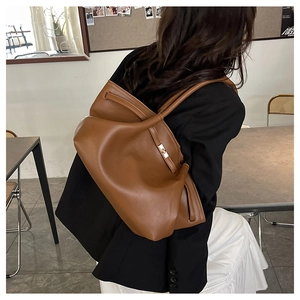 Detail of caramel brown large tote bag with golden twist lock and drawstring design