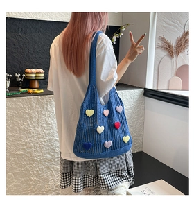 Close-up of hollow knit tote bag with colorful 3D hearts styled with casual outfit