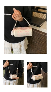 Détail du sac seau crème avec volants en mousseline rose et breloque pompon doux