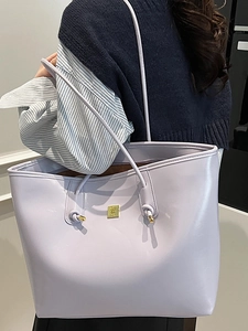 Minimalist light purple leather tote bag with gold metal logo and structured top handles