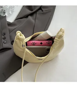 Detailansicht des geräumigen Innenraums der cremefarbenen Tasche mit Handy und Geldbörse