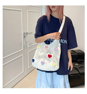 Detailed macro view of colorful crochet heart patterns on white knitted tote bag