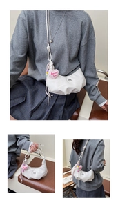 Detailansicht der weißen Moon-Bag mit Perlenkette und pinkem Barbie Girl Herzanhänger