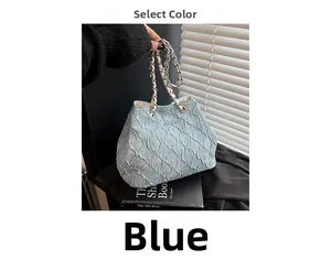 Detailed view of light blue denim bucket bag with silver chain and metal logo