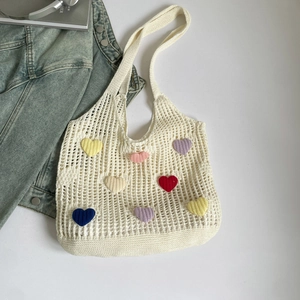 Detailed macro view of hollow knit tote bag with colorful 3D crochet hearts and mesh texture