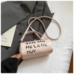 Gros plan d'un sac tonneau rose avec imprimé de lettres sur un fond de costume gris