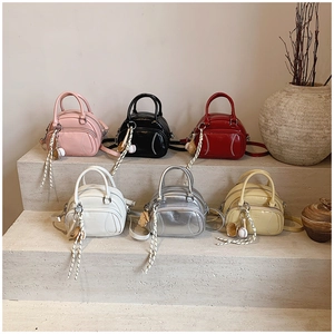 Detail of trendy pillow-style handbags in six colors with unique baseball theme charms