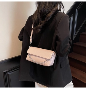 Detail of pink patent leather bag with silver chain strap and adjustable shoulder strap