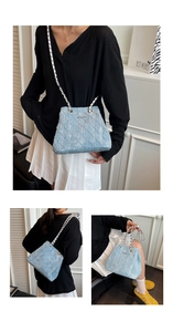 Detail of light blue pleated shoulder bag with silver chain strap and metal logo