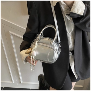 Silver metallic pillow bag featuring baseball stitch details and decorative sports charm