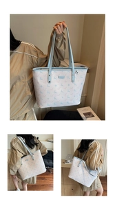 Close-up of printed tote bag with blue deer pattern and stylish leather handle detail