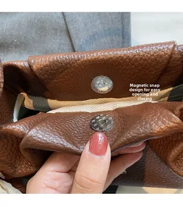 Detailed macro view of brown leather bag with magnetic snap and herringbone lining