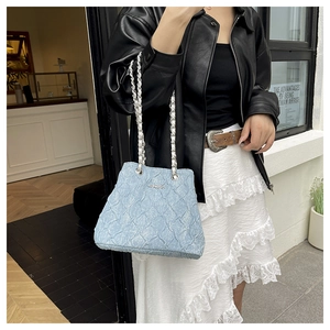 Detail of light blue chain bag featuring unique pleated texture and silver metal logo