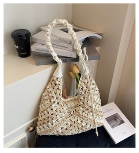 Close-up of a handmade crochet hobo bag with a pleated handle and drawstring closure