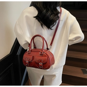 Deep red shiny Boston bag detail featuring double front pockets and silver buckles